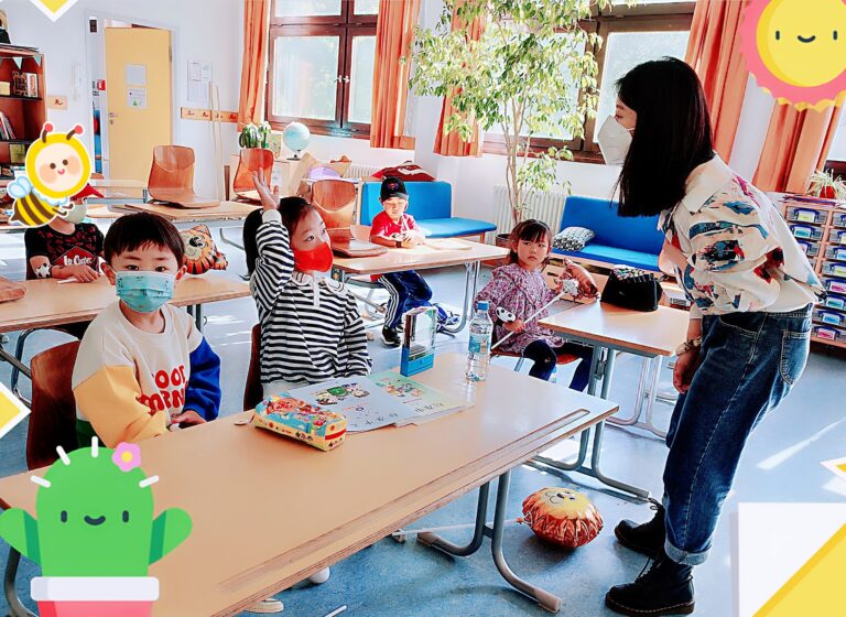 Kinder beteiligen sich am Unterricht mit ihrer Lehrerin.